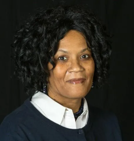 Labor Leader Vonda McDaniel - Headshot, black curly hair, black sweatshirt over a white collared buttondown